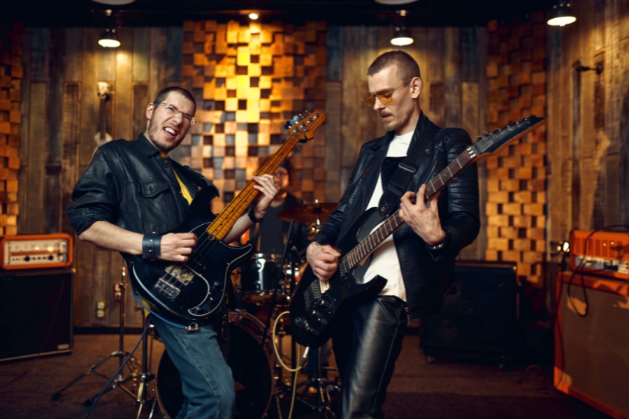 Two Guys in Leather Jackets Playing Electric Guitars Next to Each Other